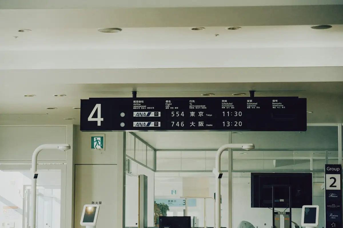 An airport departure board showing flights and times